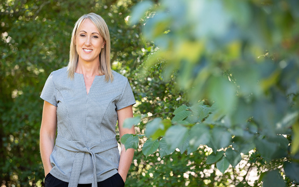 sue-in-garden-with-hands-in-pockets-grey-top