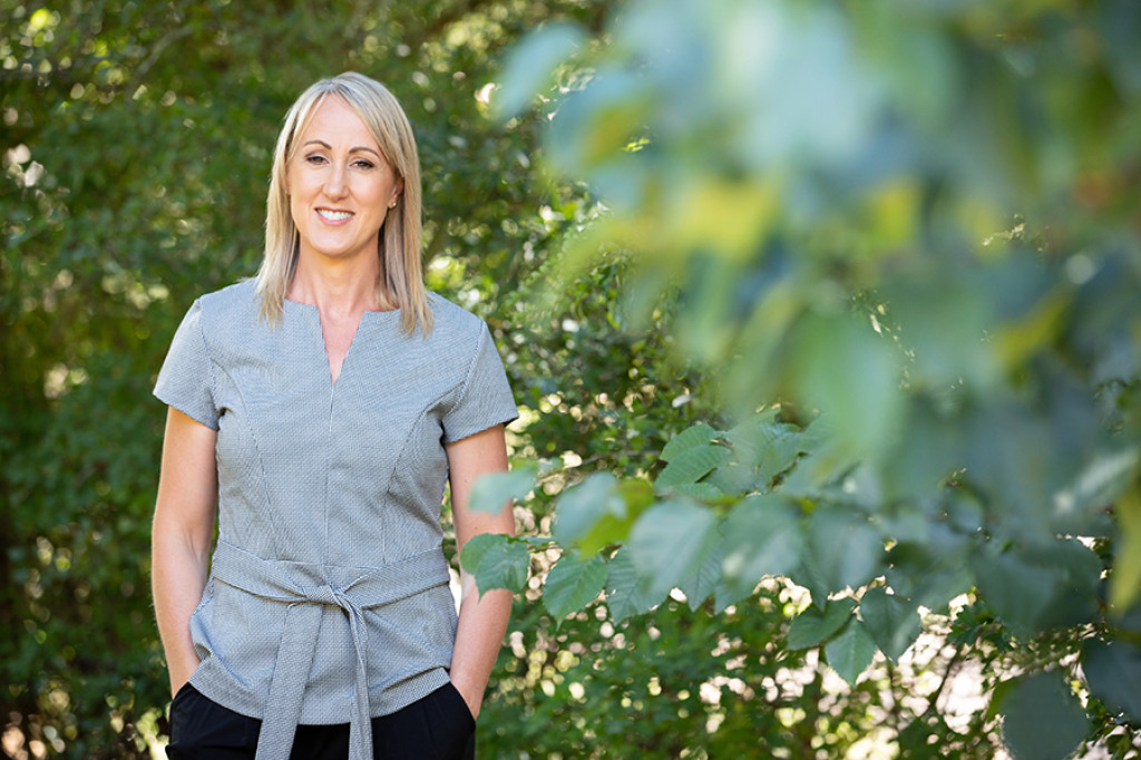 sue-in-garden-with-hands-in-pockets-grey-top